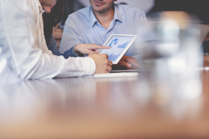 Business people working on financial data on a digital tablet.