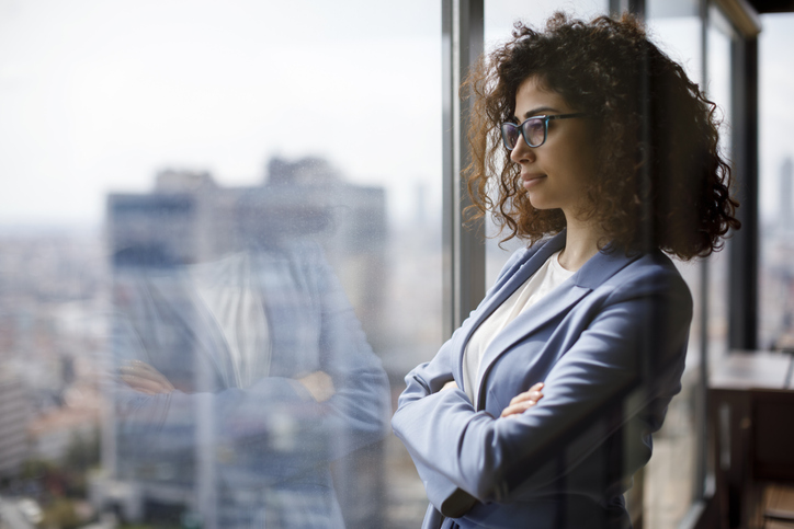 Young businesswoman looking through window